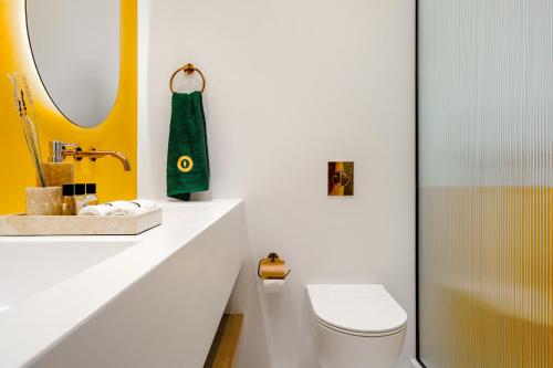 a bathroom with a toilet and a sink and a mirror at Croco Mykonos in Tourlos
