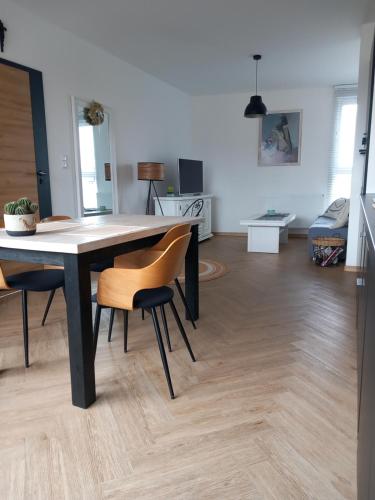 a dining table and chairs in a living room at Apartament w centrum z panoramą miasta in Bielsko-Biała
