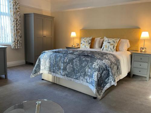 um quarto com uma cama grande e uma mesa de vidro em Cornerways Llandudno em Llandudno
