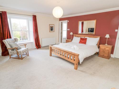a bedroom with a large bed and a chair at Jubilee House in Alnwick