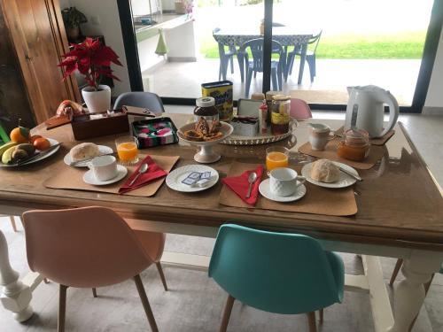 una mesa con alimentos para el desayuno y zumo de naranja en ella en Casa Penina, en Portimão