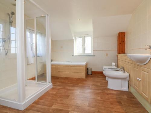 uma casa de banho com um WC, um chuveiro e um lavatório. em The Linhay em Holsworthy