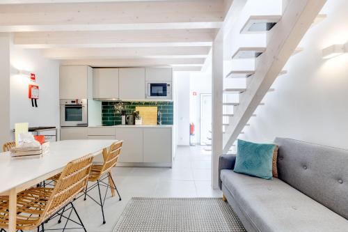 a kitchen and living room with a couch and a table at Casinhas da Praia in Vila Praia de Âncora