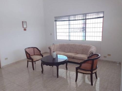 salon z kanapą, 2 krzesłami i stołem w obiekcie Casa Nahomy w mieście Chichiriviche