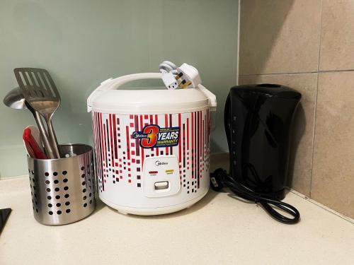 a white toaster sitting on a counter next to a utensils at Legoland-3min Walk-Afiniti Medini 2BR with Bathtub -9pax-mini playground in Johor Bahru