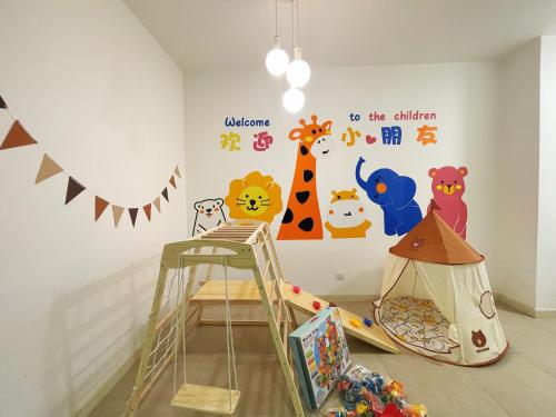 a childs room with a wall mural of animals at Legoland-3min Walk-Afiniti Medini 2BR with Bathtub -9pax-mini playground in Johor Bahru