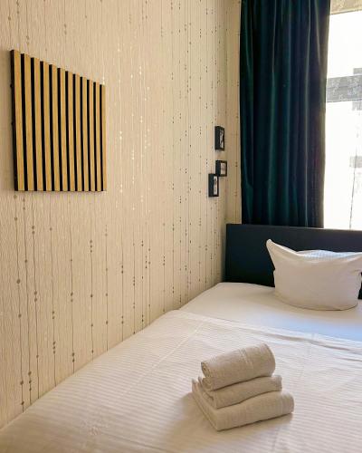 a bedroom with a bed with towels on it at Pension Am Park in Berlin