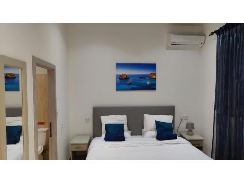 a bedroom with a large bed with blue pillows at Modern Home - Valley view Pool in Xagħra