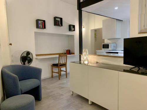 Il comprend un salon doté d'une cuisine avec une télévision et une chaise. dans l'établissement ApartHotel Riviera - DUPLEX DE JULES - Large Studio with A C - Old Town Promenade des An, à Nice