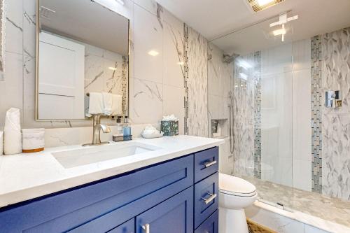een badkamer met een wastafel, een toilet en een spiegel bij Seaview Court 402 in Marco Island