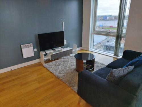 a living room with a couch and a flat screen tv at Heronsgate GH016 in London