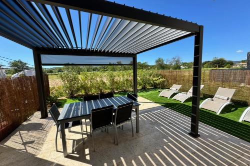 a pergola with a table and chairs on a patio at Nice house with terrace 5 min to Port Grimaud - Welkeys in Grimaud