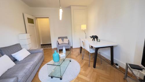 a living room with a couch and a table at 111 Stylish apartment in the city center quiet area in Lausanne