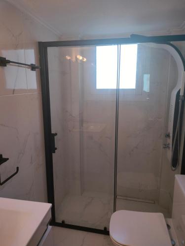 a shower with a glass door in a bathroom at Luxury sea apartment in Loutraki