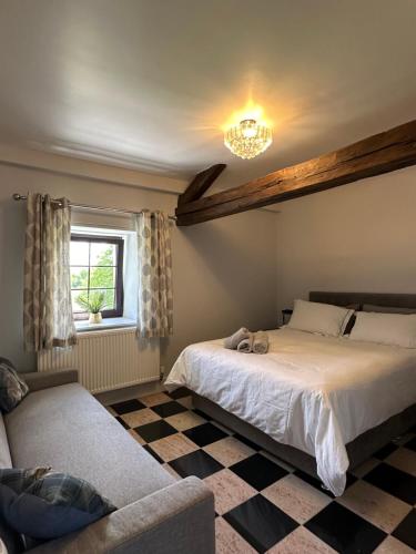 a bedroom with two beds and a couch and a chandelier at Chambres d'hôtes du Vigeant in Le Vigeant