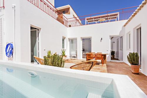 a villa with a swimming pool and a patio at Casa Rosa in Vila Real de Santo António