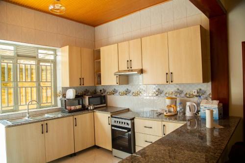 キガリにあるTWINKLE Appartmentsのキッチン(木製キャビネット、コンロ付)