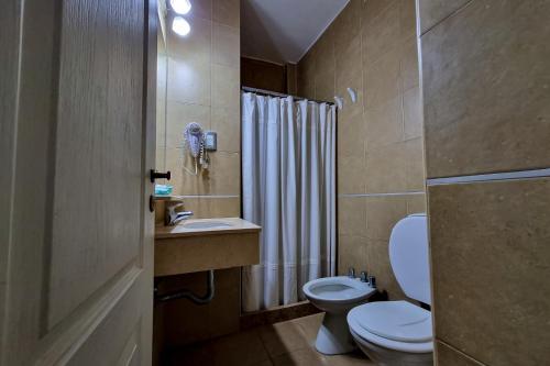 a bathroom with a toilet and a sink and a shower at Hotel Belgrano in San Luis