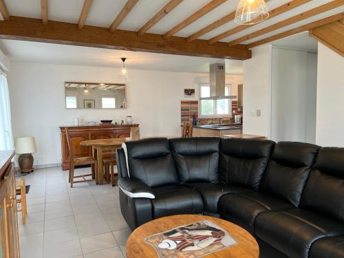 un salon avec un canapé en cuir et une table dans l'établissement 304 - Jolie maison 4 chambres à 1 kilomètre de la plage, à Fréhel