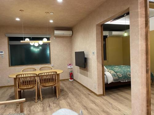 a room with a table and chairs and a bed at Villa 悠生凪 "yunagi" in Kose
