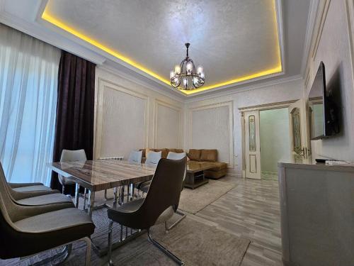 uma sala de estar com uma mesa de jantar e um sofá em Huvaydo Residence Apartment em Tashkent