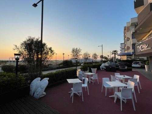 un gruppo di tavoli e sedie di fronte a un edificio di Hotel Ideal Soleti Hotels a Rimini