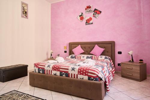 a bedroom with a bed with a pink wall at Casa laureta in Piombino