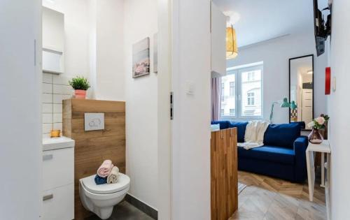 a bathroom with a toilet and a blue couch at Mikroapartament w centrum in Poznań