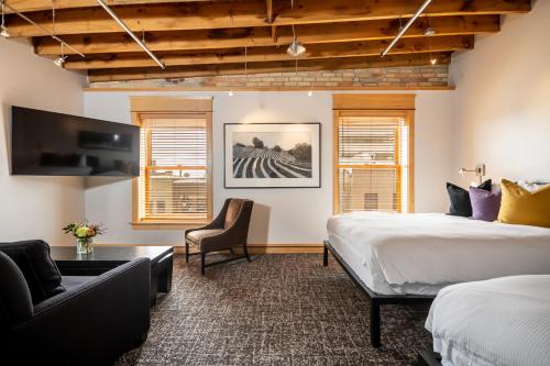 a hotel room with two beds and a couch at Hotel Donaldson in Fargo