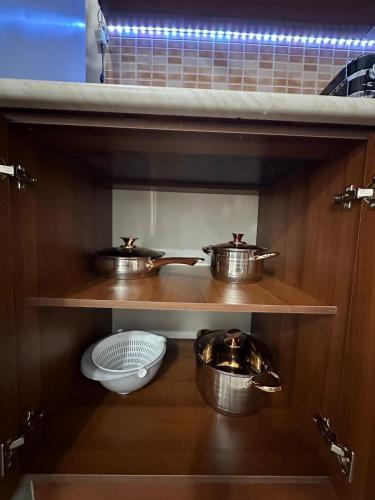 a kitchen with two pots and pans on a shelf at Rocks View Apartment in Durrës