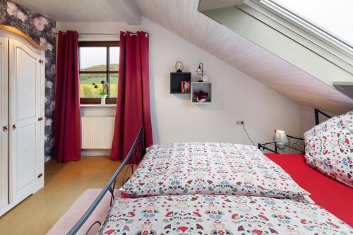 a bedroom with a bed with red curtains and a window at Landharmonie Knüll in Frielendorf