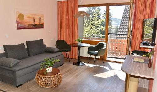 ein Wohnzimmer mit einem Sofa und einem Tisch in der Unterkunft Wohlfühlhotel Sonnengarten in Überlingen