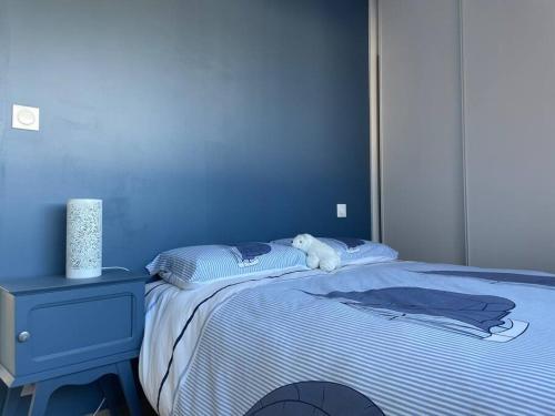 - une chambre bleue avec un lit avec un animal rembourré dans l'établissement T3 neuf - balcon - proche centre ville, à Vannes