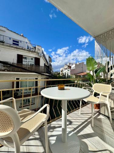 a patio with a table and chairs on a balcony at Aldara Sitges in Sitges