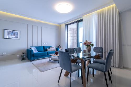 a living room with a dining table and a blue couch at JTower - Magical Apartments In City Center in Jerusalem