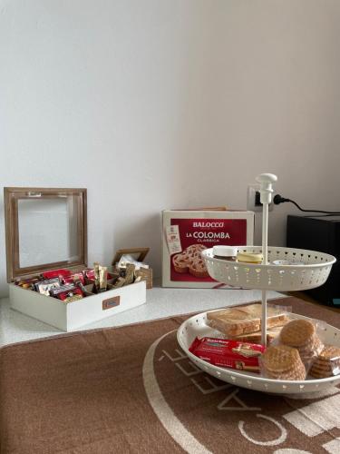 - une table avec une assiette de nourriture et une boîte de biscuits dans l'établissement Peonia Apartment - appartamento vista lago, à Lezzeno