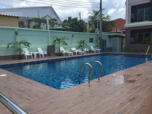 a swimming pool with chairs and a building at B Space Residence in Nong Prue