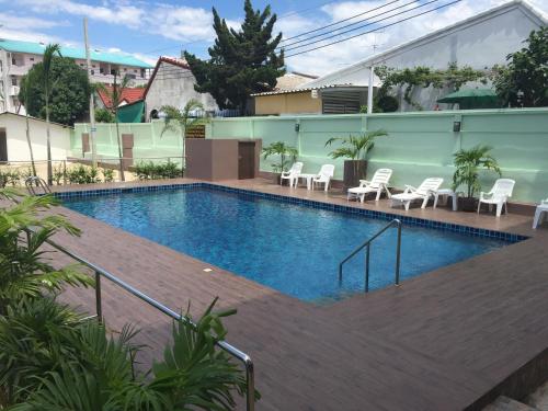 a large swimming pool with white chairs and tables at B Space Residence in Nong Prue