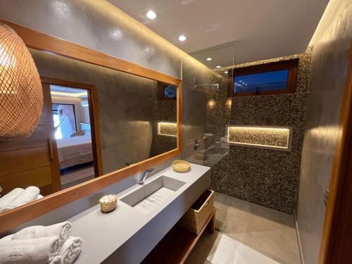 a bathroom with a sink and a mirror at Baixu Village in Arraial d'Ajuda