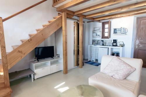 un soggiorno con divano bianco e TV di Villa Patmos Netia - Location Xoxlakas a Patmo (Patmos)