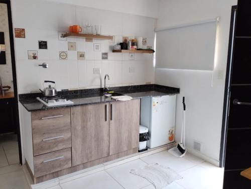 a small kitchen with a sink and a refrigerator at Complejo calle Cordoba in General Roca
