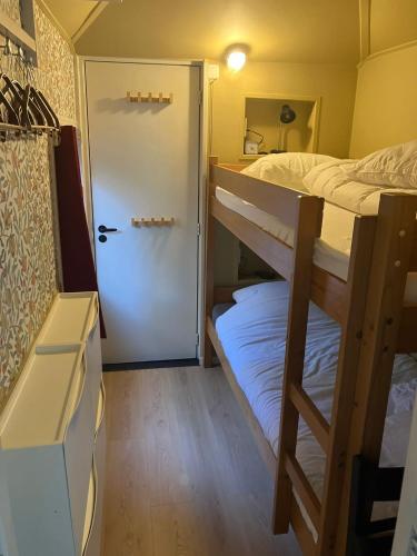 a room with two bunk beds and a door at B en B Op Steendam, Tuinkamer onder de appelboom in Steendam