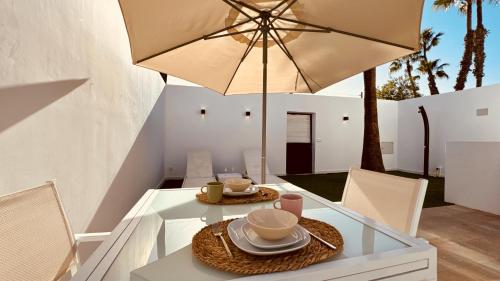 uma mesa de jantar com um guarda-sol e algumas cadeiras em Click&Guest - Maspalomas Serenity Villa em San Bartolomé