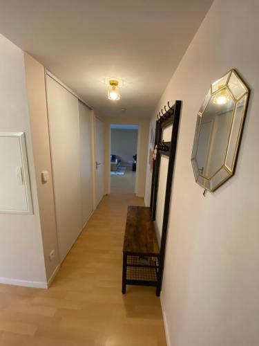 un couloir avec une table et un miroir mural dans l'établissement Appartement moderne T3 Cesson, à Cesson-Sévigné