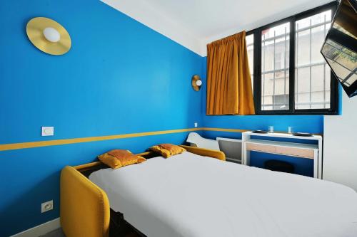 a bedroom with a large bed and a blue wall at Cosy studio - Belleville in Paris