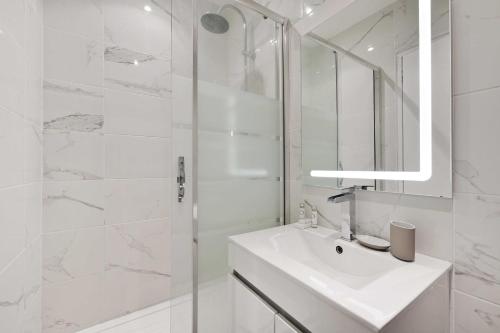 a white bathroom with a sink and a shower at Cosy studio - Belleville in Paris