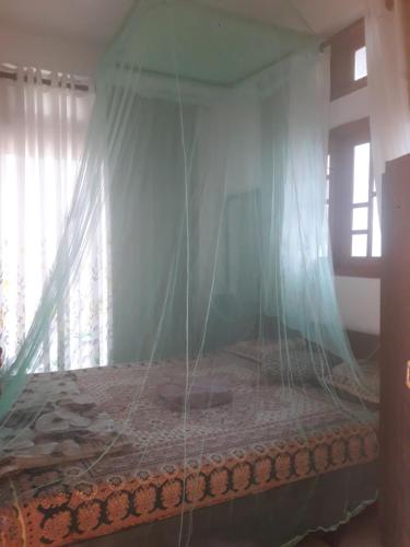 a bedroom with a bed with a mosquito net at WATHSALA HOME VILLA(homestay) in Ella