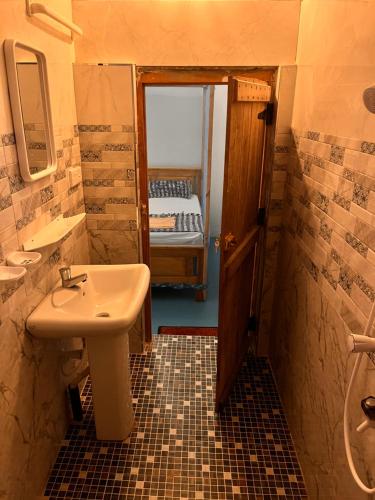 a bathroom with a sink and a bathroom with a bed at YOGA SHACK in Arugam Bay