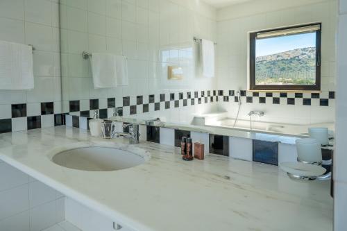La salle de bains blanche est pourvue d'un lavabo et de toilettes. dans l'établissement Attico sul Poetto, à Cagliari