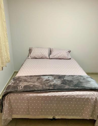 a bed with polka dot sheets and a pillow at QUARTO UNIFESP Prox RODOVIAS, MARGINAS, ALPHAVILLE in Osasco